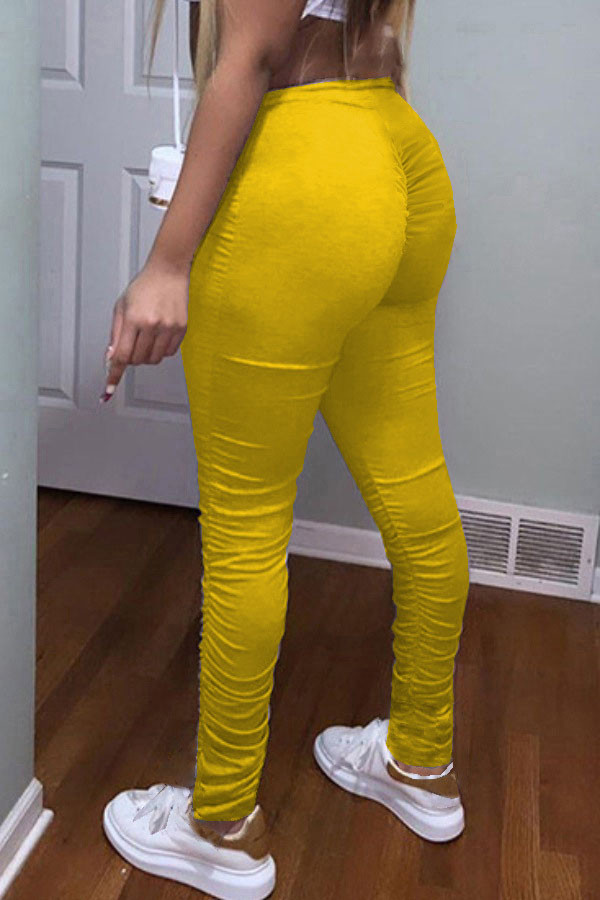 Pantalones de tubo drapeados de color amarillo con bragueta elástica y color sólido