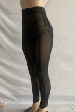 Lápis preto sexy em patchwork transparente de cintura alta com fundo de cor sólida