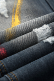 La stampa di strada multicolore strappata crea vecchi pantaloni dritti