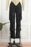 Pantalones de color sólido con bolsillo de patchwork de vendaje sólido de calle regular de cintura baja lápiz negro