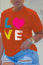 Orangefarbene Patchwork-T-Shirts mit O-Ausschnitt und süßem Tagesdruck
